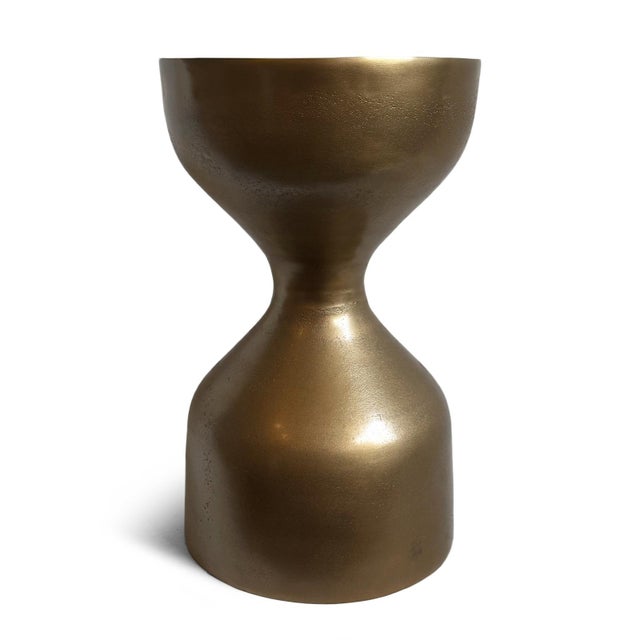 Round antiqued brass finish hourglass aluminum side table. Each will vary slightly in patina / textures. Weighs approx. 15...