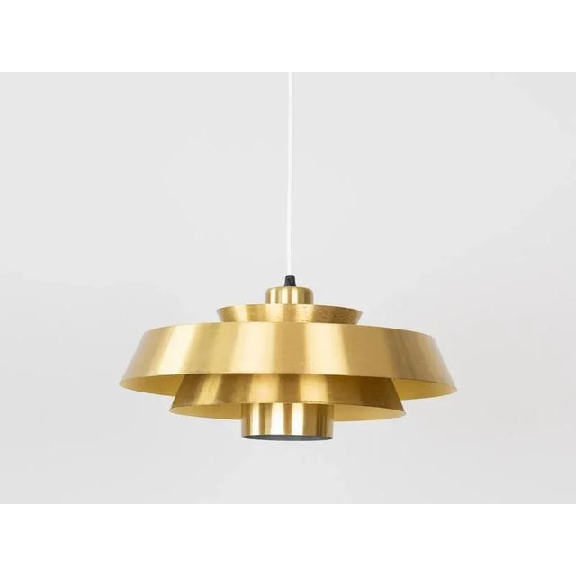 The brass Nova lamp, designed by Jo Hammerborg in 1963. When lit, the lamp provides a soft, glare-free downward glow,...