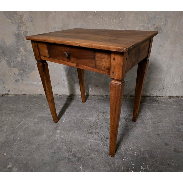 Antique rectangular writing table, likely from the 18th century, crafted primarily from solid walnut. It features a drawer...