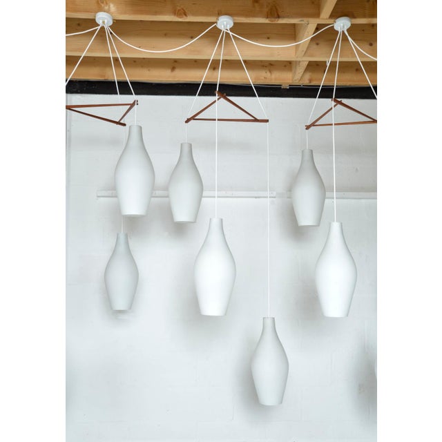 This large 1960s danish pendant light has three beautiful cased white/frosted glass ‘bowling pin’ drops, hung from a...