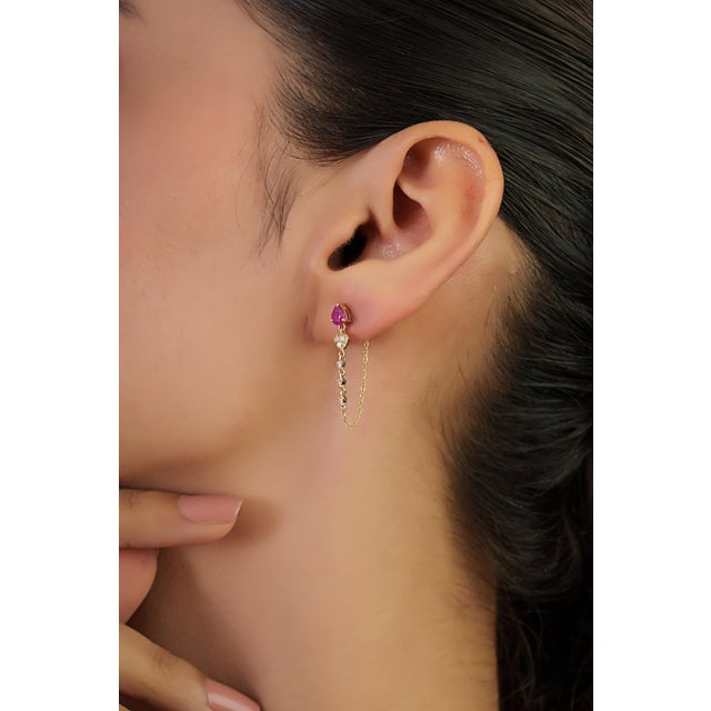 These chain drop earrings feature 0.57 carats of pear-cut rubies set in 14K yellow gold. Each ruby measuring 3.5 x 5 mm....