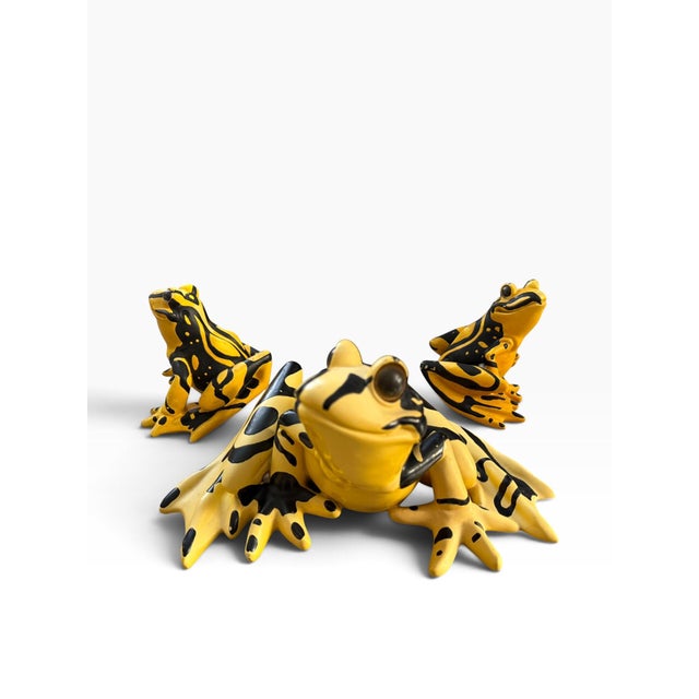 Striking set of three whimsical frog sculptures in a bold yellow and black color palette, dating to 2003. The trio...