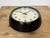 Wall clock produced by Gents of Leicester in England during the 1950s. It features a brown bakelite frame, an iron dial,...