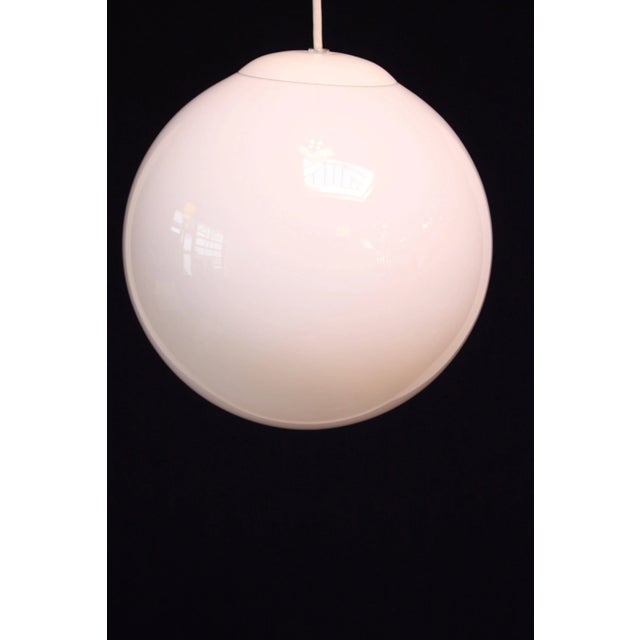 1970s American modern pendant in a complete 'orb' shape with no opening at the bottom. However, the cased glass allows for...