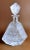 Hand-cut and ground crystal bottle; its shape is unusual and peculiar, even the stopper echoes the lines of the bottle; an...