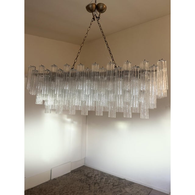 Scenographic italian hand-made chandelier with clear “tronchi”, elements of Murano glass. Huge chandelier in a bath of...