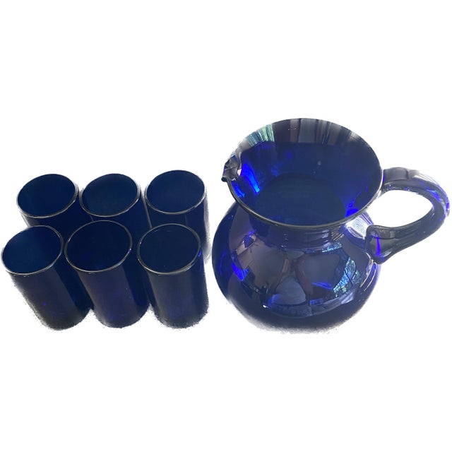 This vintage hand blown cobalt blue glass pitcher comes complete with six matching hand blown glasses, making it a...