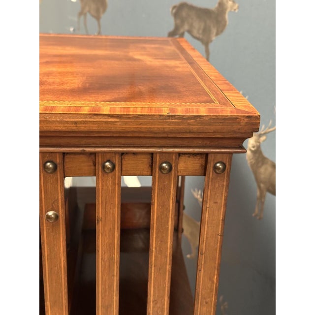 A magnificent antique mahogany revolving bookcase featuring exquisite inlay work, accented with satinwood. This high-...