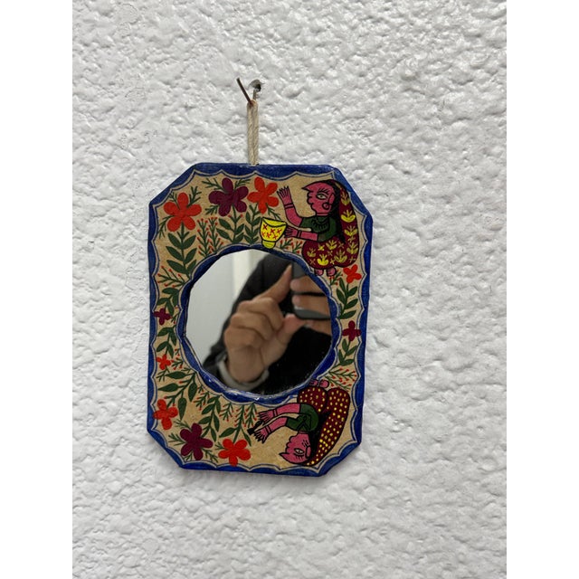 Design Plus Gallery presents a Mithila Folk Hand-Painted Art Wall Mirror. This small wall mirror showcases hand-painted...