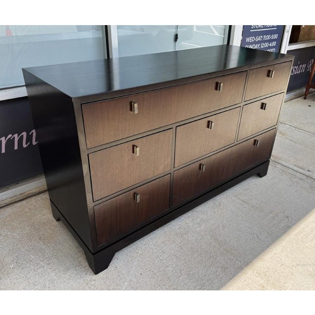 The Crate & Barrel Ferris 7-Drawer Dresser features a clean, modern silhouette with a rich dark wood finish, streamlined...