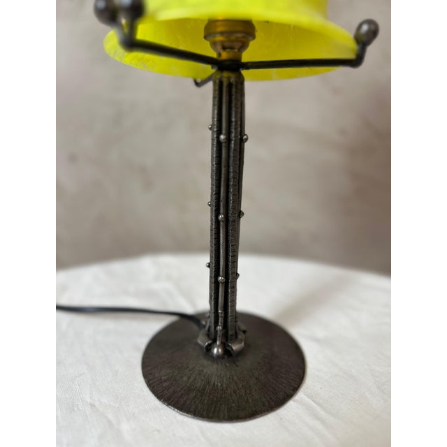 An elegant Art Deco table lamp dating from the 1930s, combining a patinated wrought iron frame with a superb glass shade...