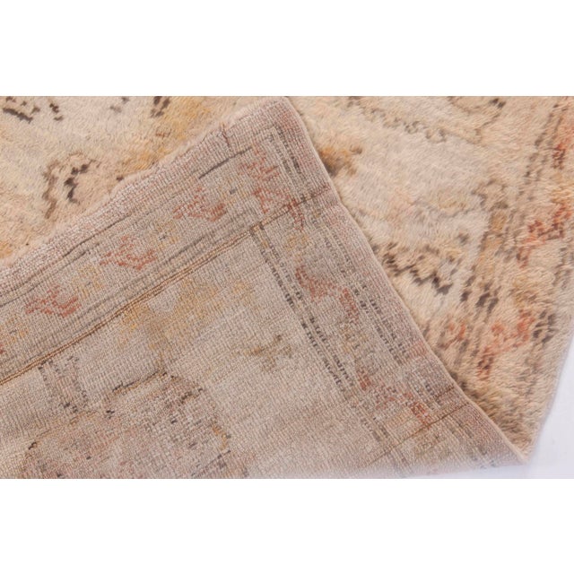 This antique Turkish Oushak rug exemplifies the refined elegance and storied heritage of Anatolian craftsmanship....
