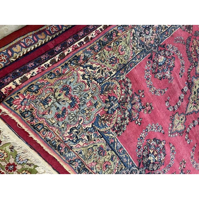 Lilian rug in soft pink and complementary shades. It features a beautiful floral design with a busy central field and a...