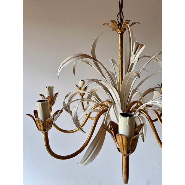 Italian eight-light chandelier manufactured by masca, dating to the 1970s. Constructed in gilt metal with white painted...