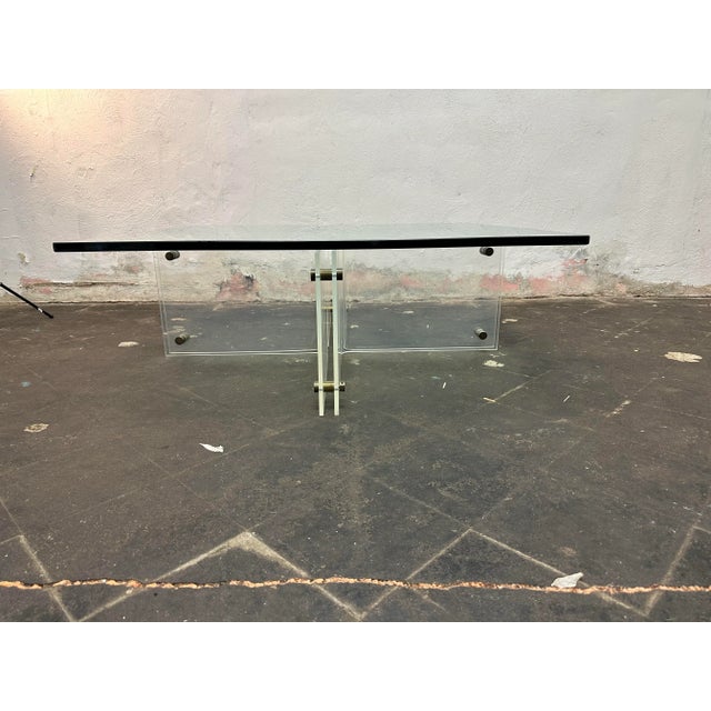 This is a gorgeous Lucite and glass with brass rivets coffee table by Neal Small. The glass is excellent and 3/4" thick...