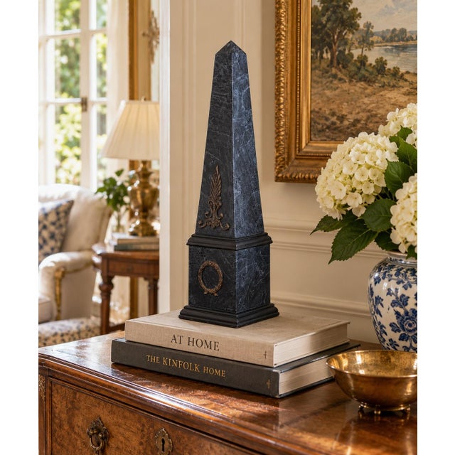 A beautifully proportioned black and grey faux-marbled patterned obelisk with brass mounts. The sculptural silhouette and...