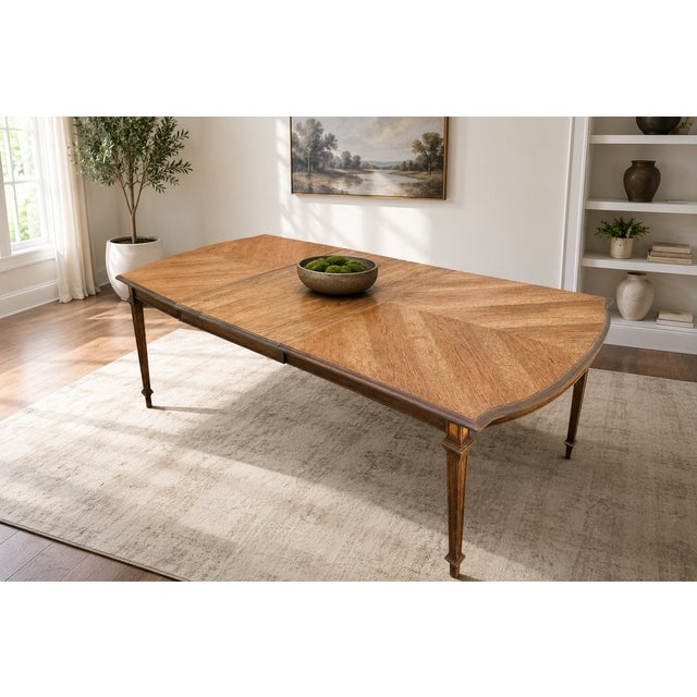 A striking vintage extendable dining table featuring a dramatic chevron-pattern veneer top, elegant tapered legs, shaped...