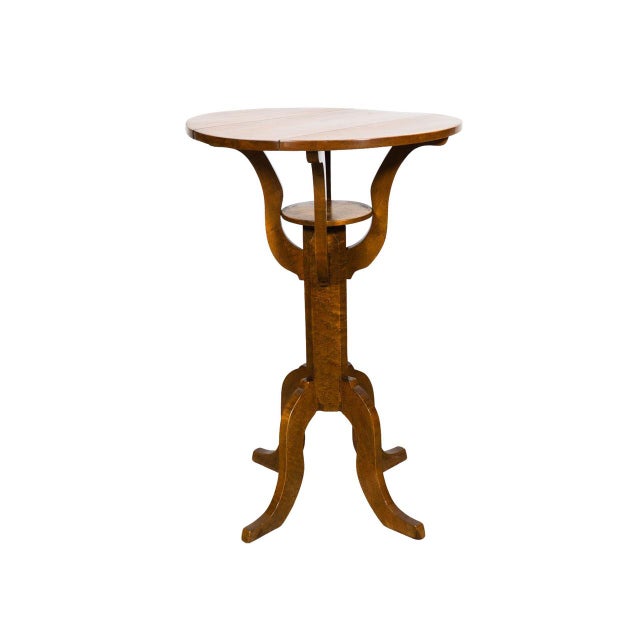 Antique Biedermeier side table with round three-board wood top. Sculpted central column and tripod base. Warm honey brown...