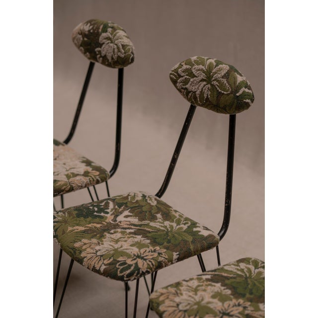 Playful set of four Italian modernist dining chairs. Made out of an elegant and slim black steel frame combined with...