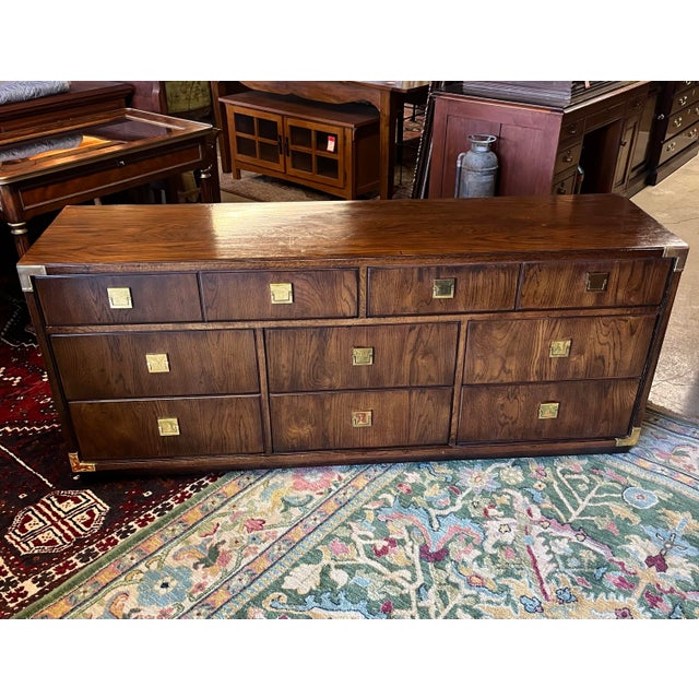 Interesting and stylish campaign style dresser by Thomasville. Features eight spacious drawers with interesting brass...