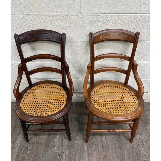 This is a matched pair of antique Victorian armchairs, dating to approximately 1890–1910. Each features a curved ladder...