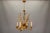 Mid-Century Hollywood Regency four-light chandelier crafted in gilt metal, featuring sculptural cattail (reed) motifs....