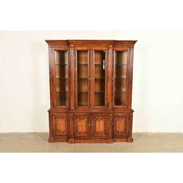 A gorgeous French Regency or Neoclassical style lighted breakfront bookcase or dining cabinet In the manner of Baker...