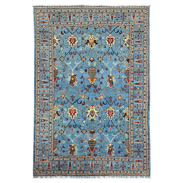 This blue Sultani wool rug features a Persian-style floral pattern of branching vines, blossoms, and richly colored...