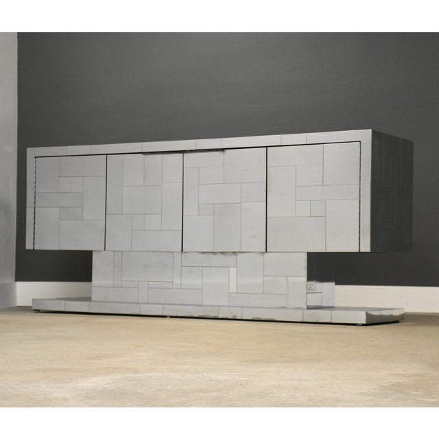 This Paul Evans Cityscape cabinet credenza features a sleek, modernist design with patchwork of reflective chrome...