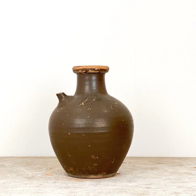 A 19th Century Japanese pottery jar with writing and a small spout