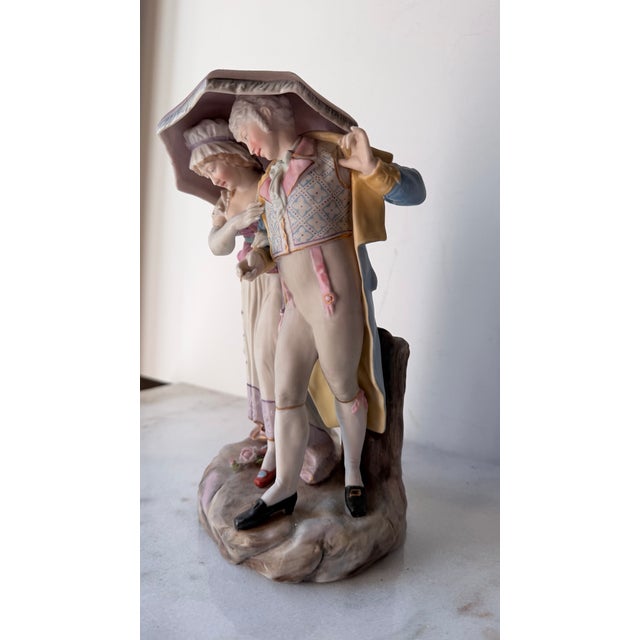 Rococo 18th-Century Courting Couple Sharing a Parasol Under Pastel-Colored Period Attire. Glazed and Matte Porcelain Figurine For Sale - Image 3 of 15