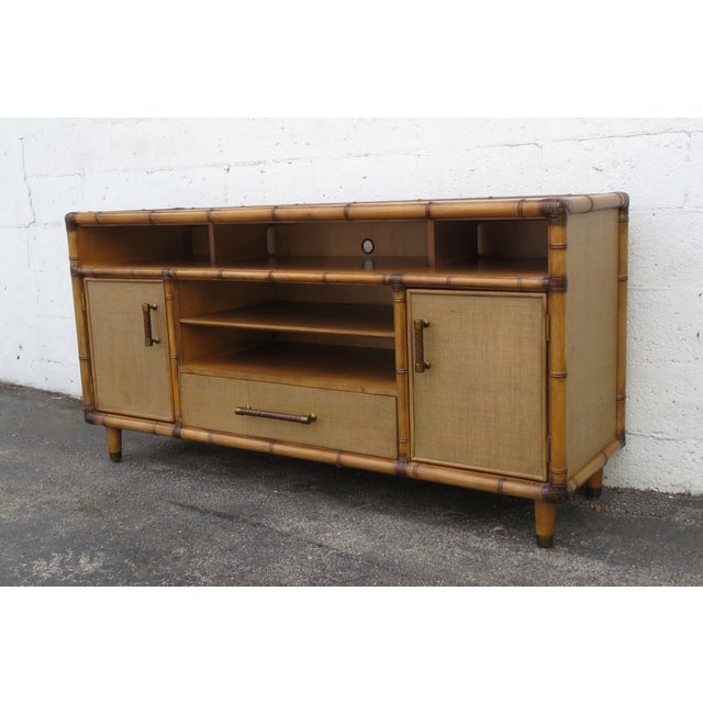 This magnificent Media Cabinet is made of wood, rattan, and caning. The TV Console was made by a fine furniture company...