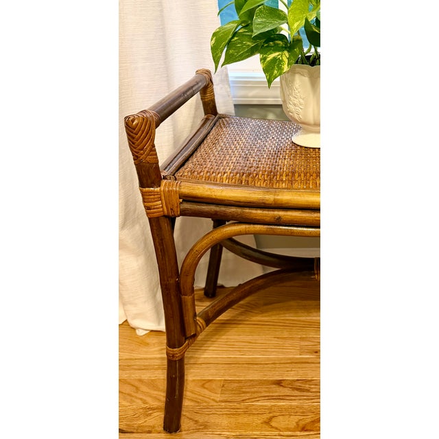 Vintage bamboo and rattan accent bench with a light gloss finish, varying in shades of golden and medium brown,...
