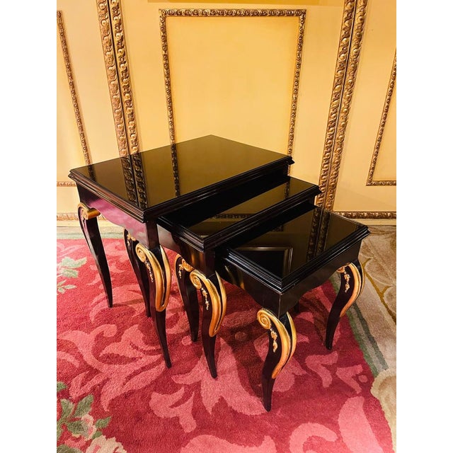 Set of designer 3 side tables in Empire style Solid beechwood black painted and partially gilded. Curved frame on curly...
