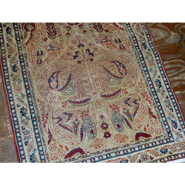 Persian Kerman Lavar rug in original condition, it has some low pile. The rug is prayer in beige and burgundy shades, made...