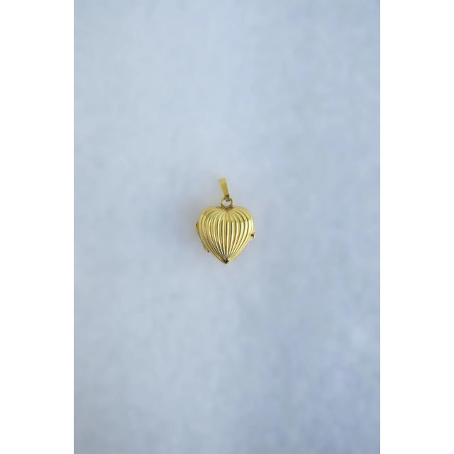 This is part of Chairish’s Fine Jewelry assortment. A beautiful, puffed heart charm locket with fluted design in 14-karat...