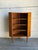 This teak corner cabinet uses an angular footprint to fit neatly into a room corner. Three open shelves and an elevated...