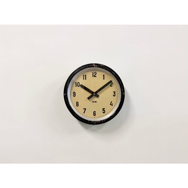 This wall clock was manufactured by IBM in the United States in the 1950s. It features a black metal frame, an iron...