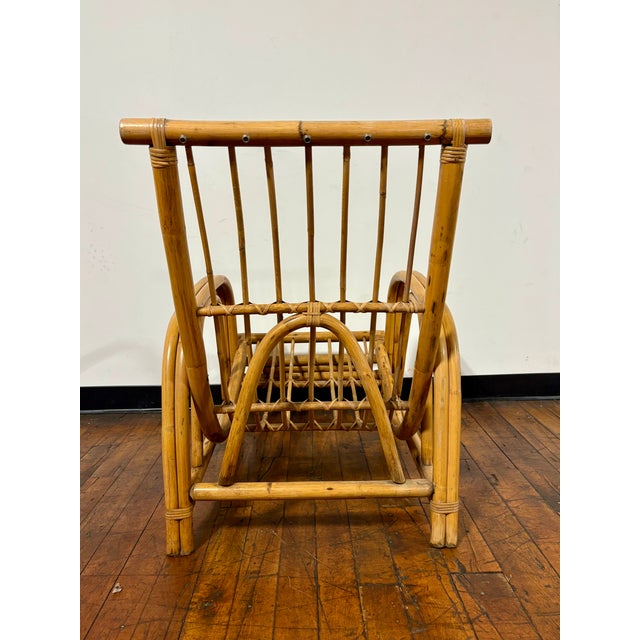 Mid-Century Modern low profile rattan lounge chair. Chair features a distinctive curved, airy silhouette typical of mid-...