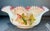 Cased art glass brides bawl/basket featuring hand painted leaves and bird design.. White exterior with a pink interior and...