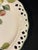 This round platter from Brunelli features a blooming fig branches motif, a delicate pierced lattice design, embossing and...