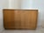 Modern light oak cabinet on a plinth base, featuring its original brass knobs with a gorgeous patina. This vintage light...