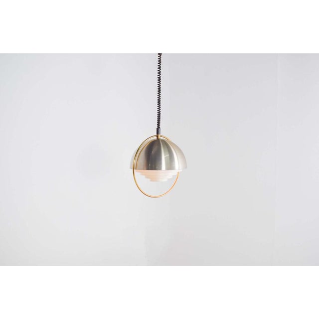 Pendant Light space age from 1970s. This pendant light consists of a half globe made of aluminium with white metal louvre...
