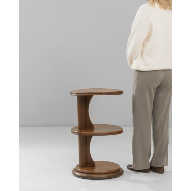 This 1940s French Modern three-tier side table features a clean, architectural silhouette that reflects the eras shift...