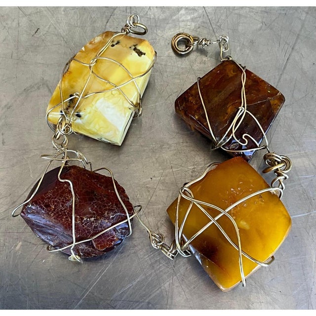 This vintage bracelet showcases four freeform amber stones, each left in a raw, organic shape with natural fractures,...