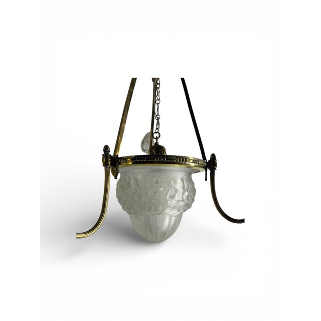 This is a french antique brass chandelier. It is art deco, with frosted glass. Great addition to a dining table.