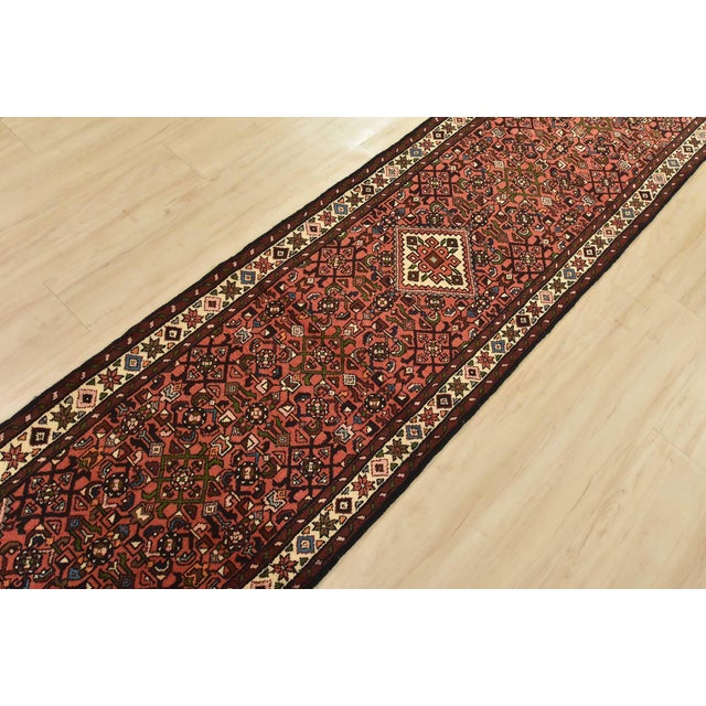 An authentic vintage tribal Hamedan runner hand-knotted with fine wool and natural dyes. This nomadic rug features a...