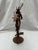 A single vintage tole candelabra featuring stylized oak leaves, ribbons, and acorns surrounding three taper candle holders...