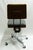 Industrial rolling office chair manufactured by United Chair, featuring a sturdy metal frame, vinyl and fabric upholstery,...