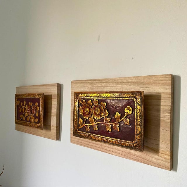 A pair of sculptural wall art panels composed of two early 20th-century Chinese giltwood floral carvings, each mounted on...